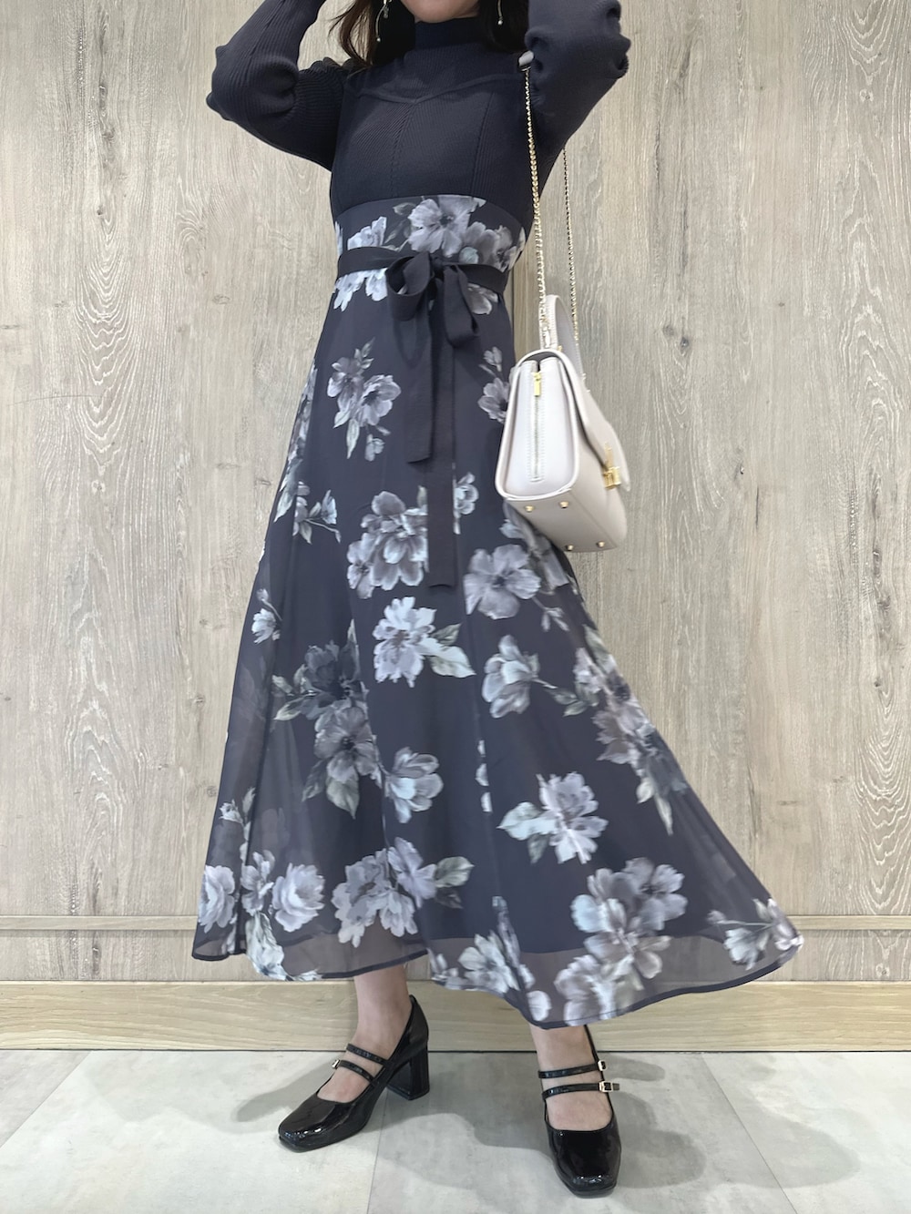 ピンク系のショルダーバッグ、ブラウン系のパンプス、パープル系のワンピースを着用したレディースの秋コーディネートの9枚目の写真