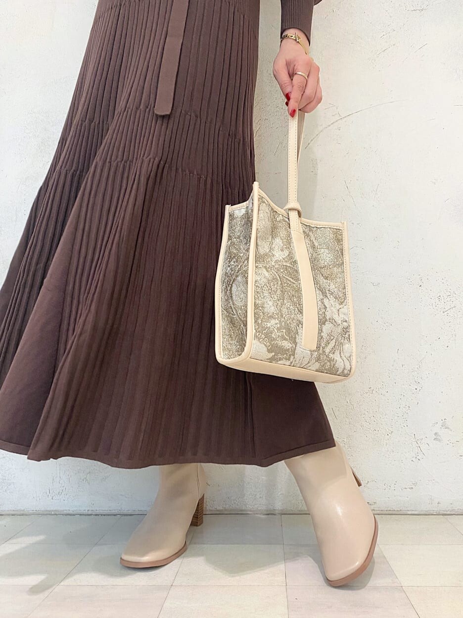 ベージュ系のハンドバッグ、ベージュ系のブーツ、ブラウン系のワンピースを着用したレディースの秋コーディネートの10枚目の写真