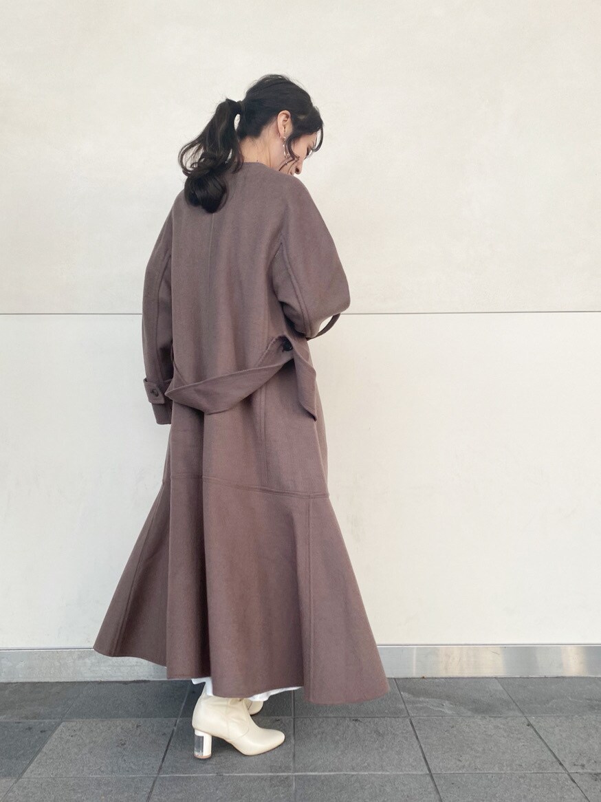 ホワイト系のブーツ、ホワイト系のスカート、ベージュ系のニット/セーターを着用したレディースの冬コーディネートの4枚目の写真