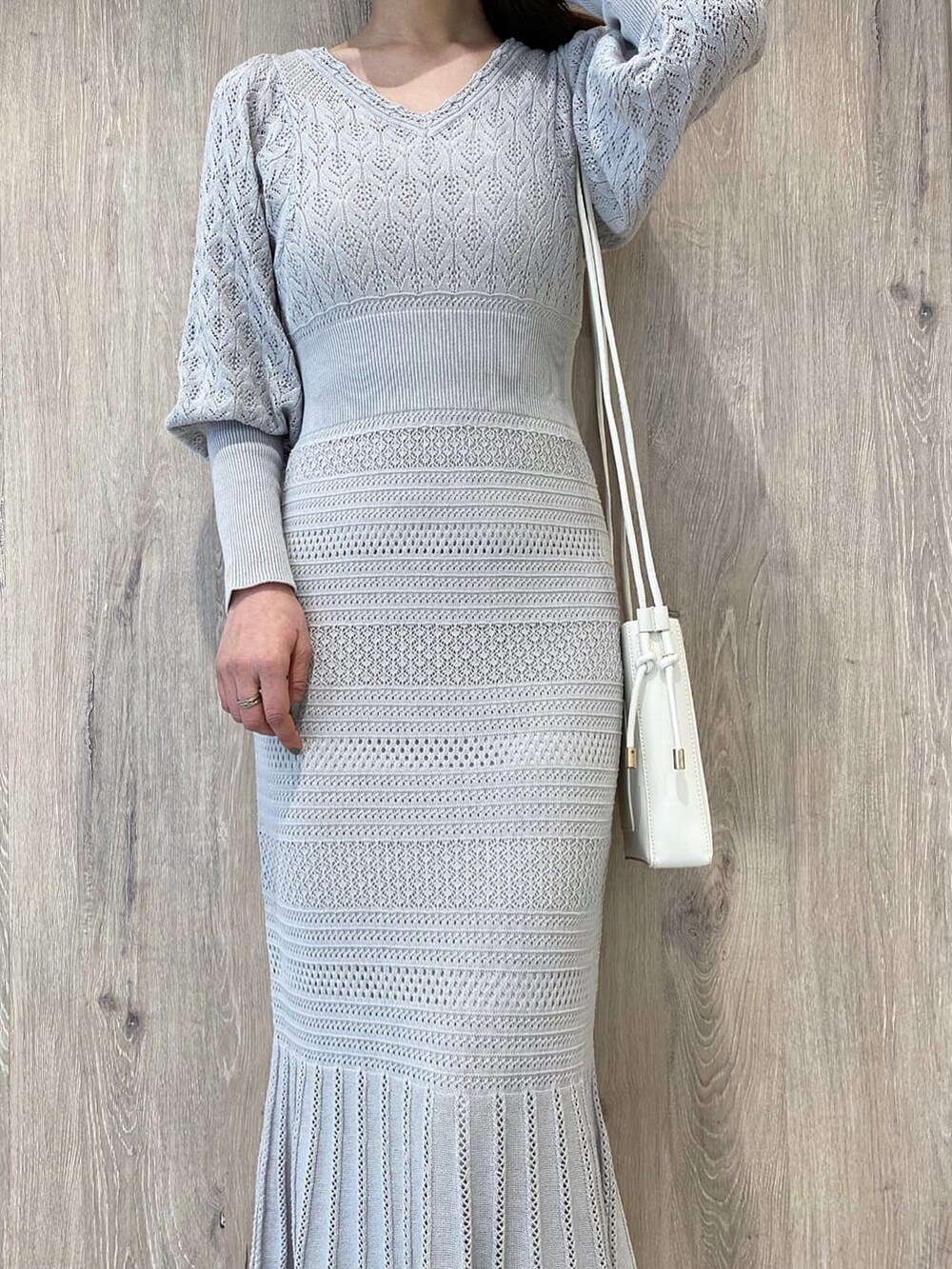 ベージュ系のパンプス、グレー系のワンピース、ホワイト系のハンドバッグを着用したレディースの冬コーディネートの5枚目の写真