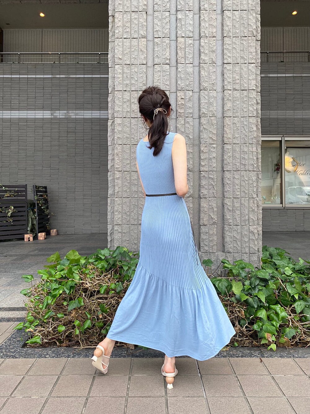 ブルー系のワンピース、ブラウン系のサンダル、ゴールド系のピアス（両耳用）を着用したレディースの夏コーディネートの2枚目の写真