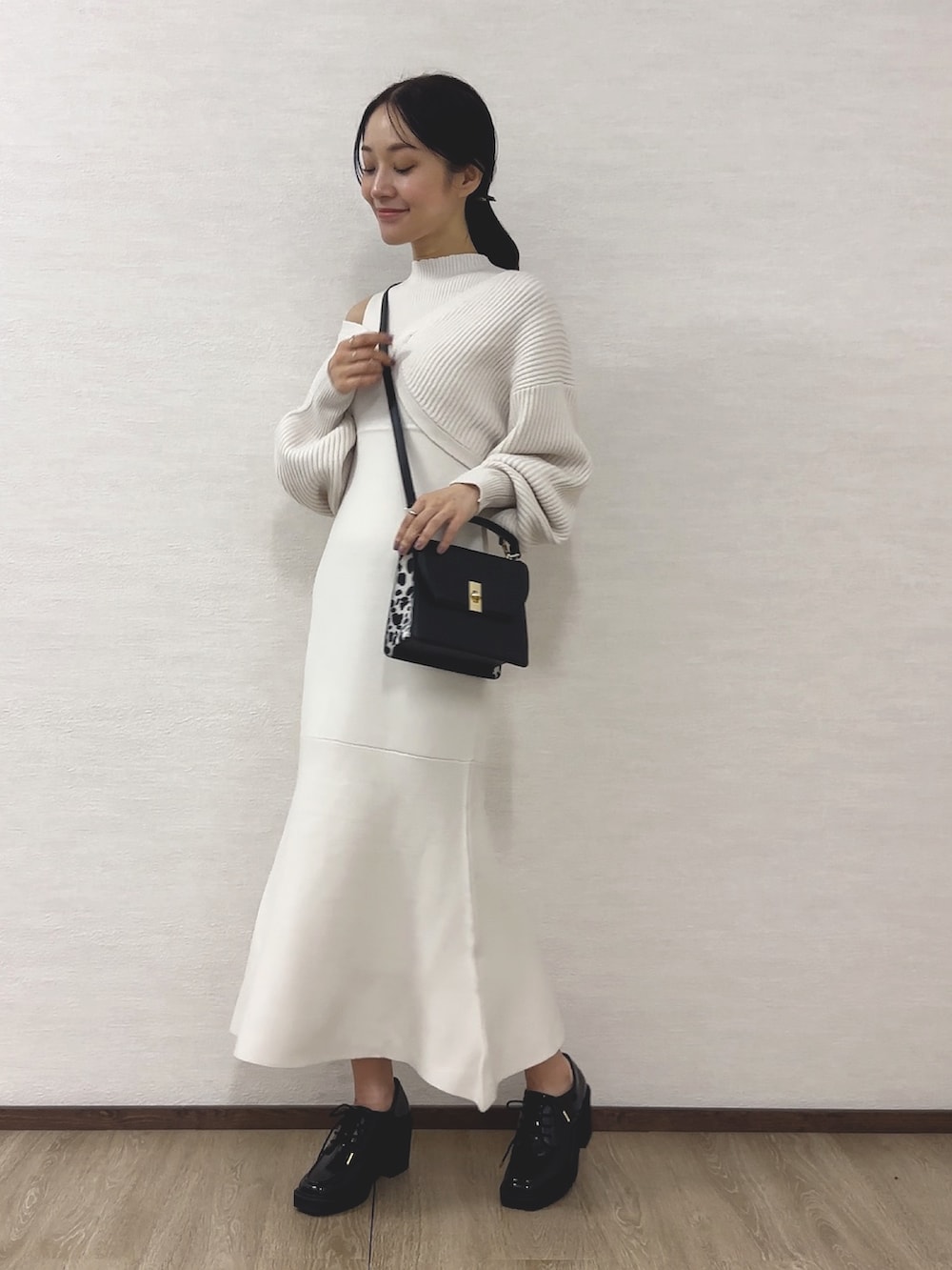 ホワイト系のワンピース、ブラック系のハンドバッグ、ブラック系のローファーを着用したレディースの秋コーディネートの2枚目の写真