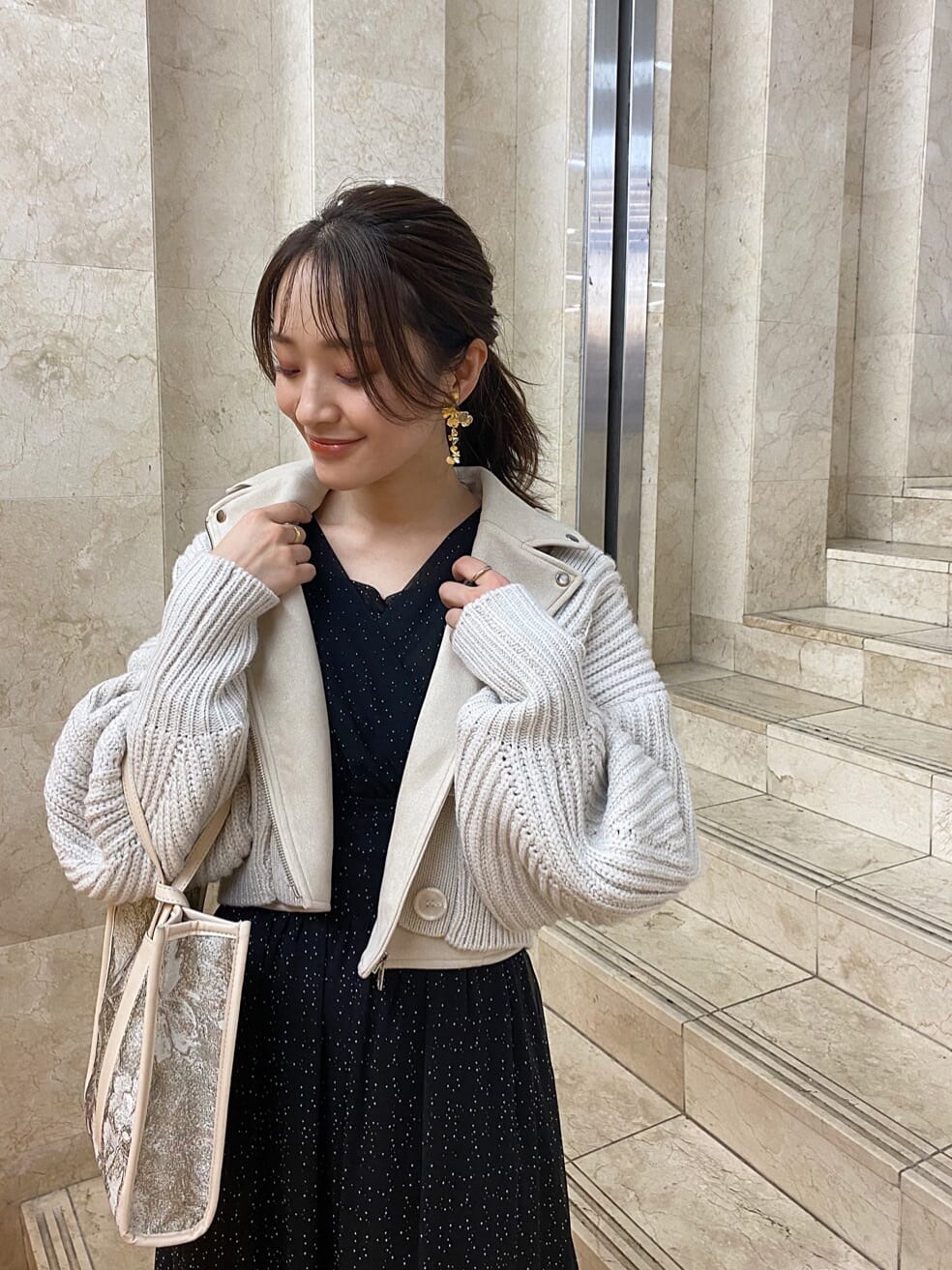 ベージュ系のハンドバッグ、ホワイト系のテーラードジャケット、ベージュ系のブーツを着用したレディースの秋コーディネートの3枚目の写真