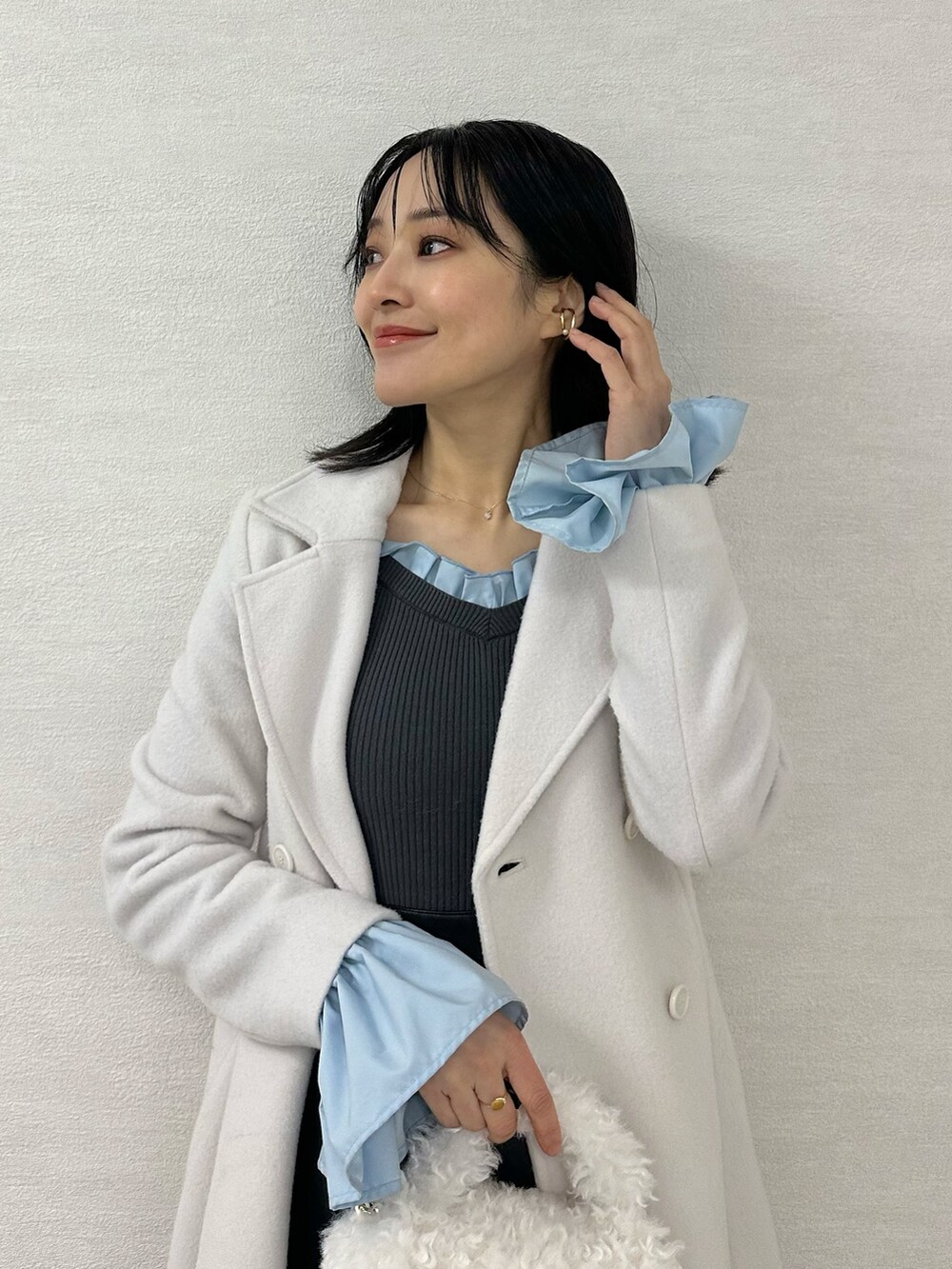 グレー系のブーツ、グレー系のニット/セーター、ブラック系のスカートを着用したレディースの冬コーディネートの5枚目の写真