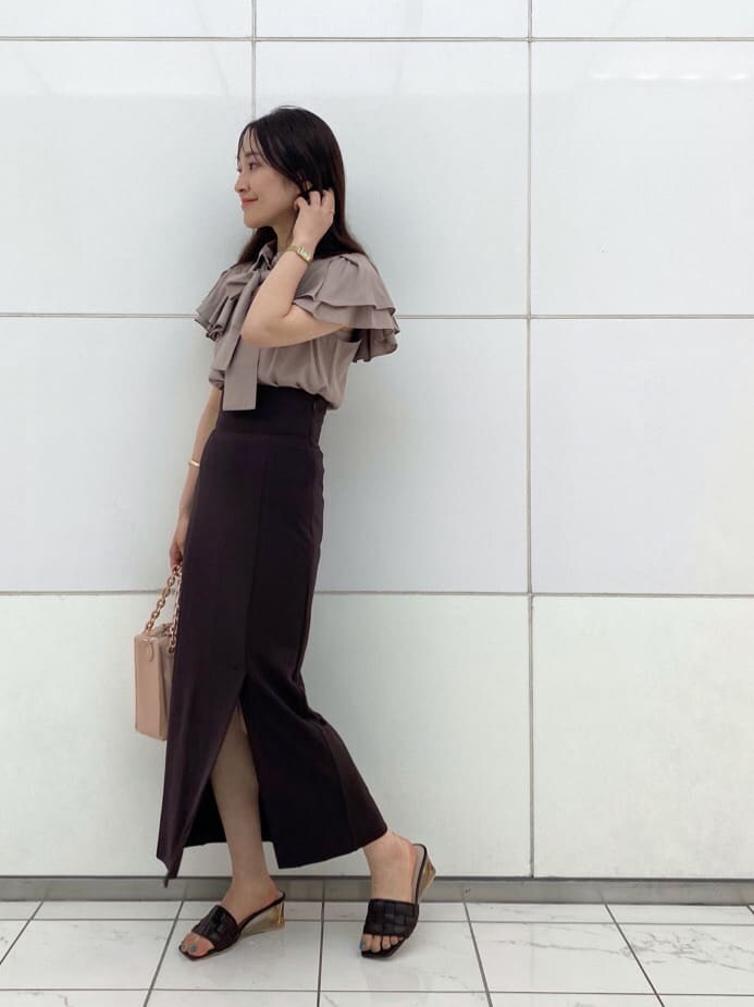 ピンク系のハンドバッグ、ブラウン系のサンダル、ベージュ系のシャツ/ブラウスを着用したレディースの夏コーディネートの3枚目の写真