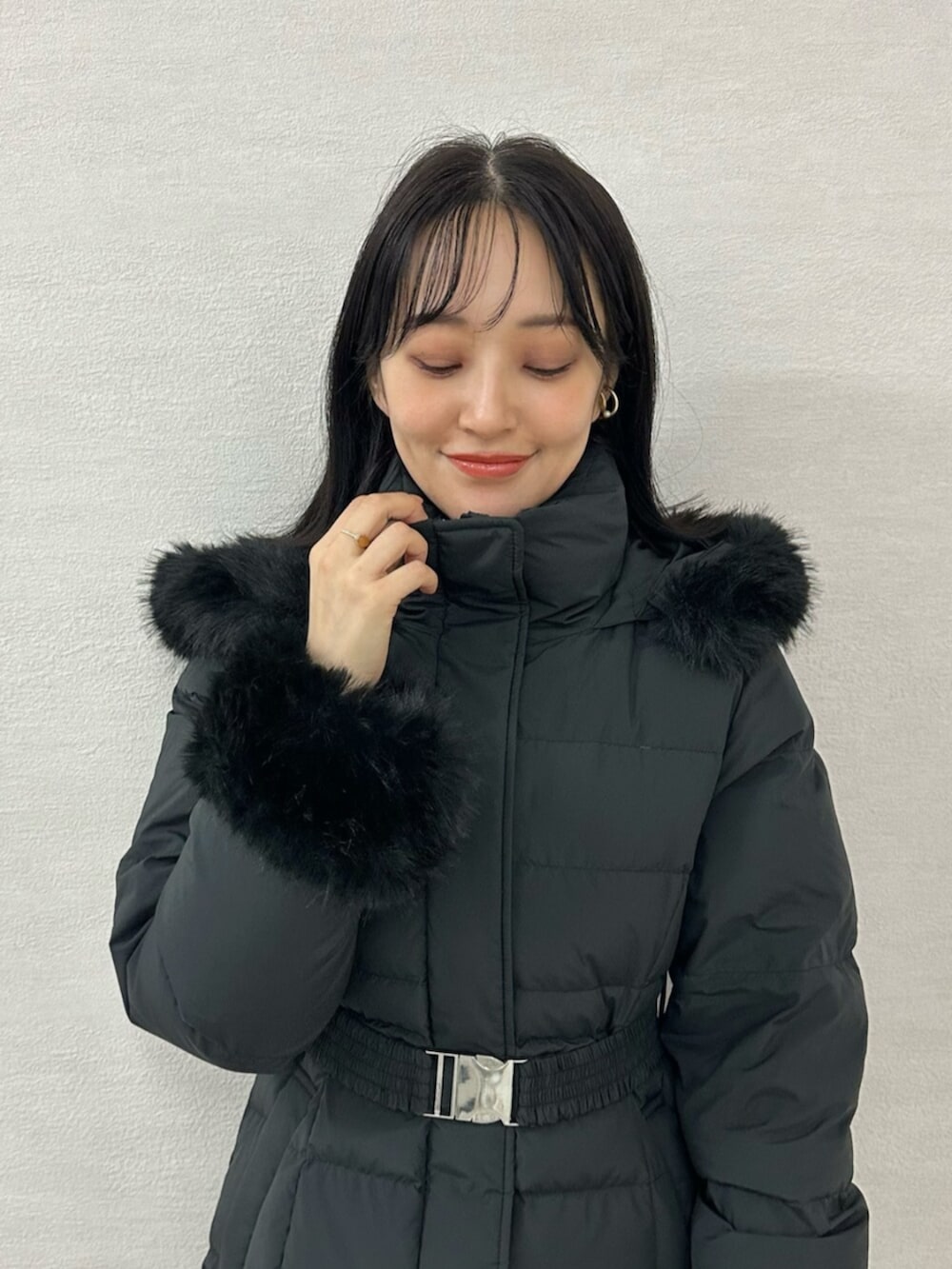 グリーン系のワンピース、ブラウン系のブーツ、ブラック系のダウンジャケット/コートを着用したレディースの冬コーディネートの8枚目の写真