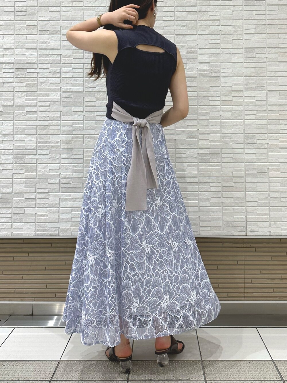 ブラック系のチューブトップ、ブルー系のスカート、ブラウン系のサンダルを着用したレディースの夏コーディネートの4枚目の写真