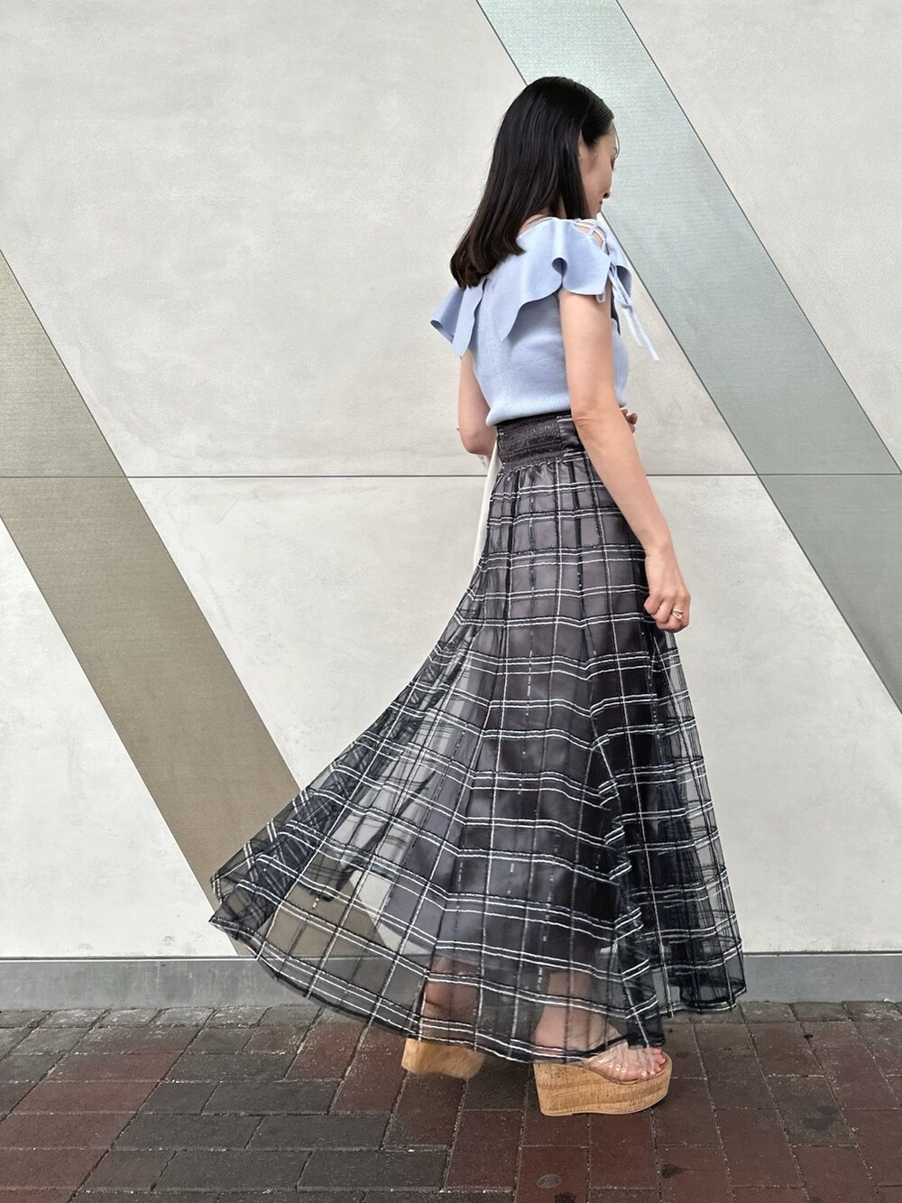 その他のサンダル、ブラック系のハンドバッグ、ブルー系のニット/セーターを着用したレディースの春コーディネートの2枚目の写真