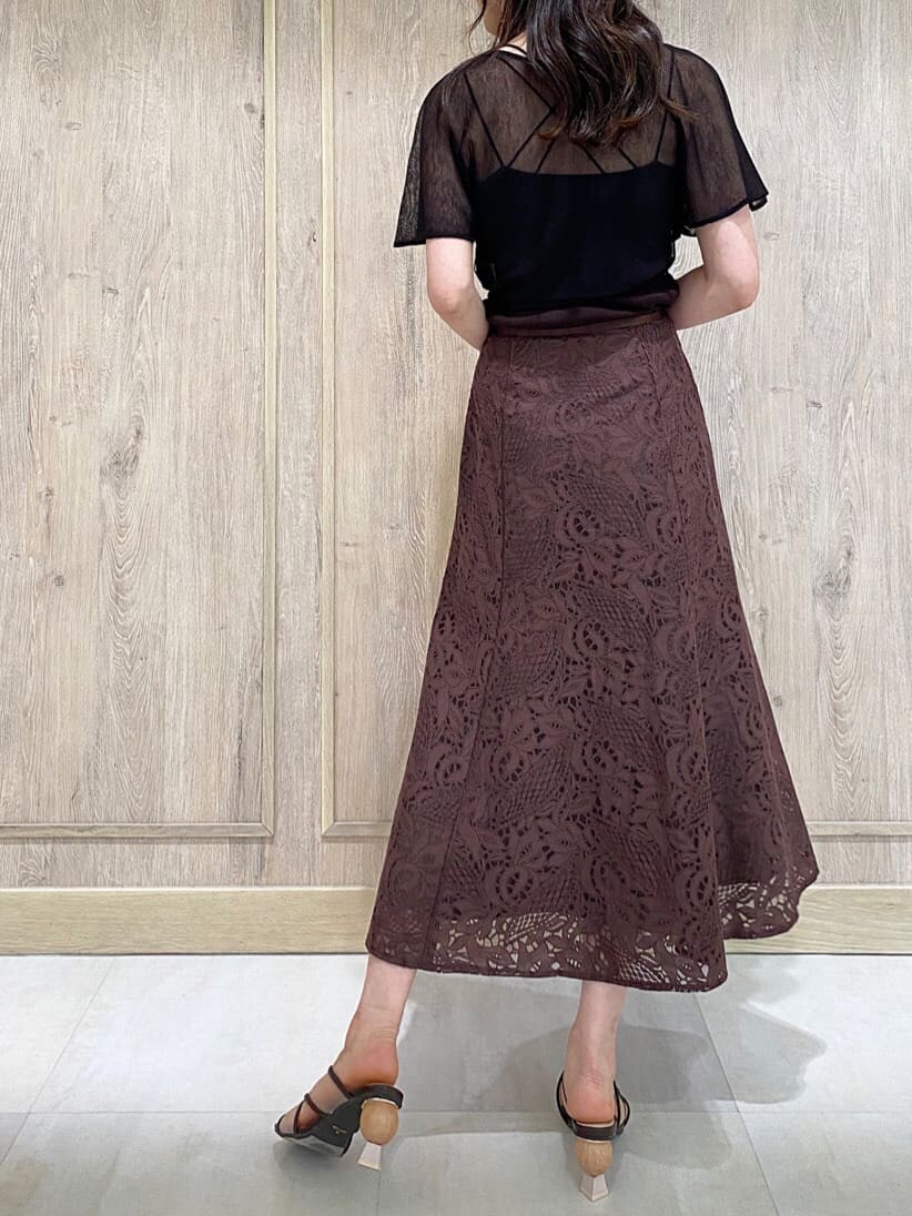 ホワイト系のハンドバッグ、ブラウン系のスカート、ブラウン系のニット/セーターを着用したレディースの夏コーディネートの4枚目の写真