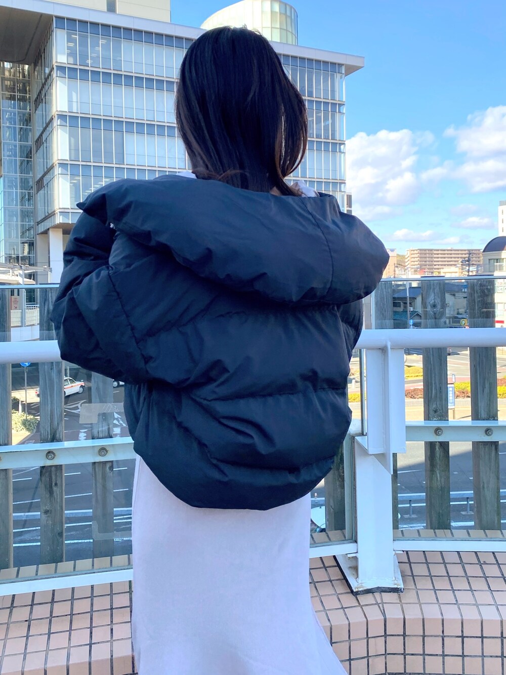 ブラック系のブーツ、ベージュ系のワンピース、ブラック系のダウンジャケット/コートを着用したレディースの冬コーディネートの7枚目の写真