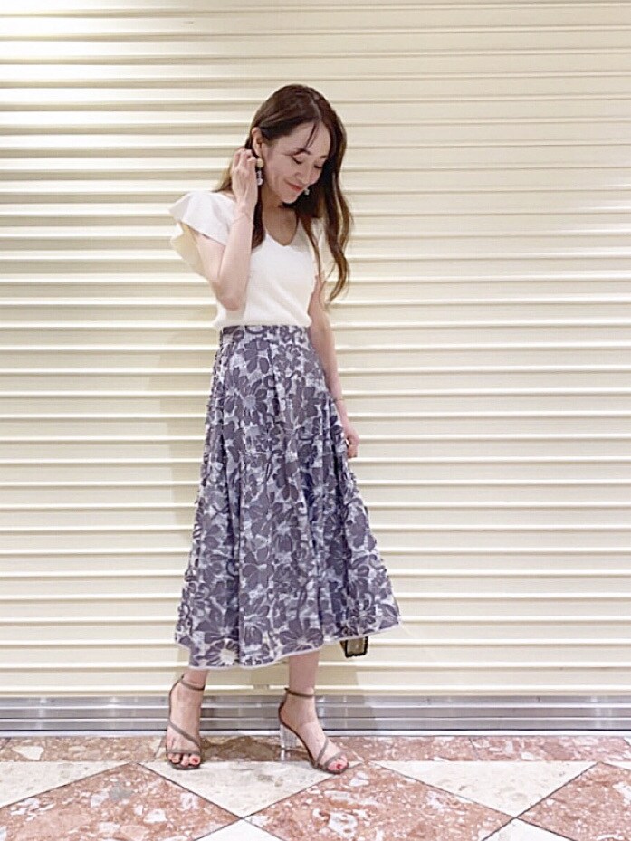 ブラウン系のサンダル、ブラック系のハンドバッグを着用したレディースの夏コーディネートの2枚目の写真