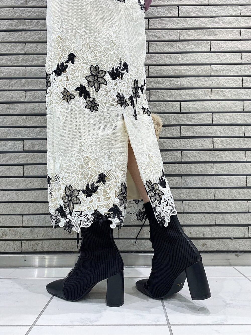 ホワイト系のスカート、ブラック系のブーツ、ピンク系のニット/セーターを着用したレディースの冬コーディネートの7枚目の写真