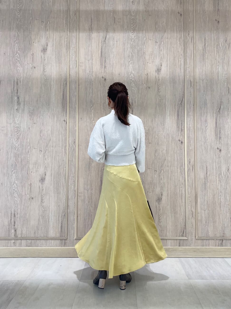 ブラウン系のハンドバッグ、ブラウン系のその他シューズ、イエロー系のスカートを着用したレディースの秋コーディネートの3枚目の写真