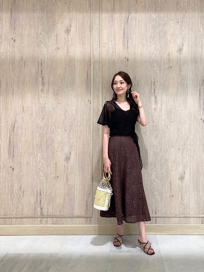 ホワイト系のハンドバッグ、ブラウン系のスカート、ブラウン系のニット/セーターを着用したレディースの夏コーディネートの2枚目の写真