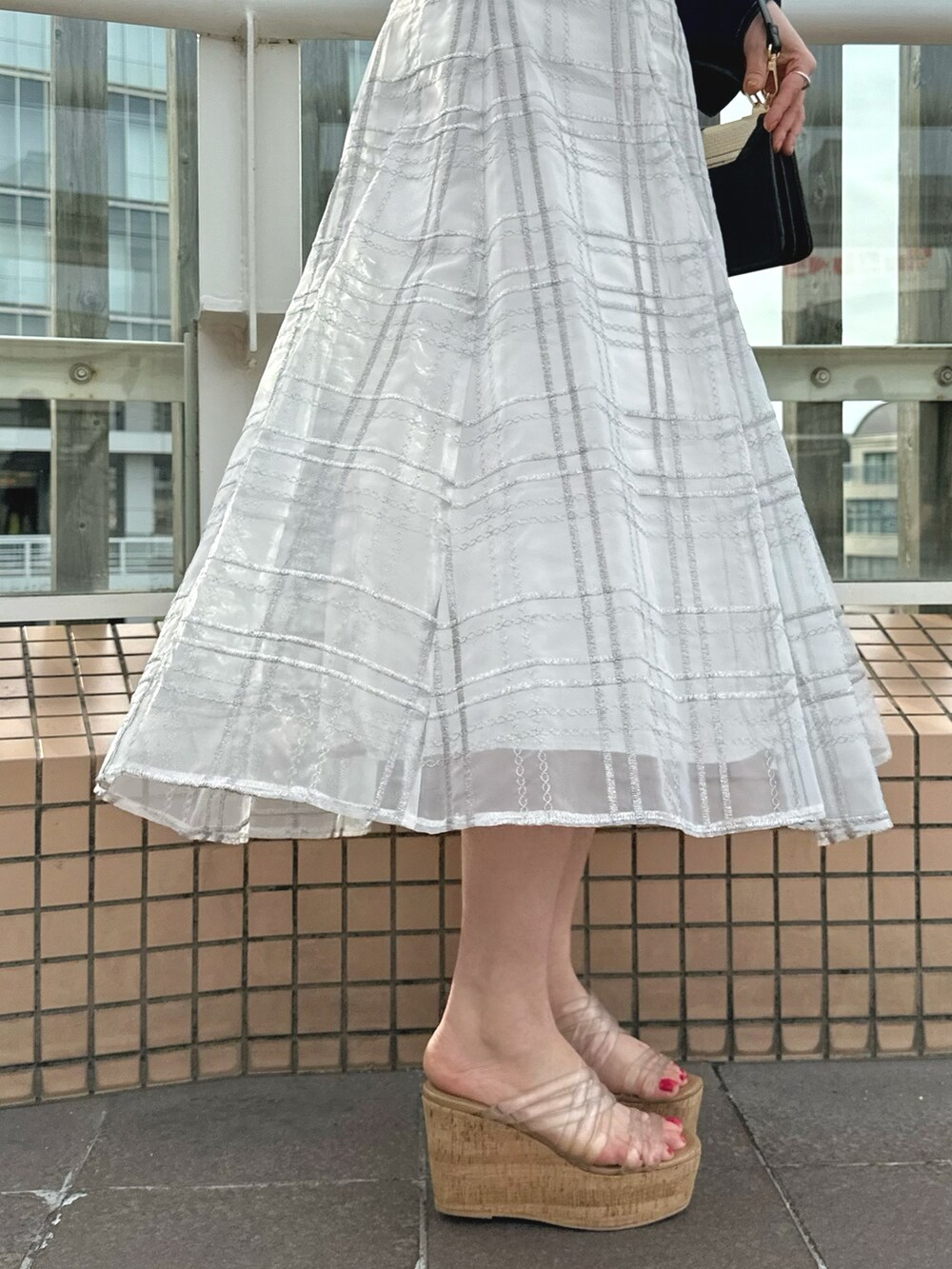 ホワイト系のハンドバッグ、グリーン系のワンピース、ブルー系のデニムジャケットを着用したレディースの春コーディネートの10枚目の写真