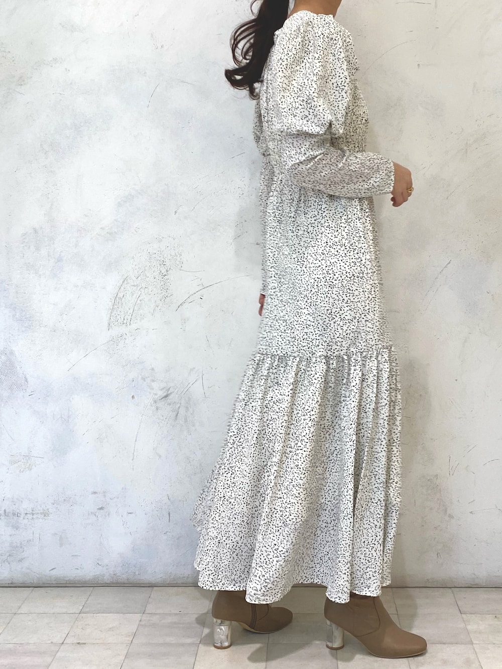 ホワイト系のワンピース、ベージュ系のブーツ、シルバー系のイヤリングを着用したレディースの秋コーディネートの3枚目の写真