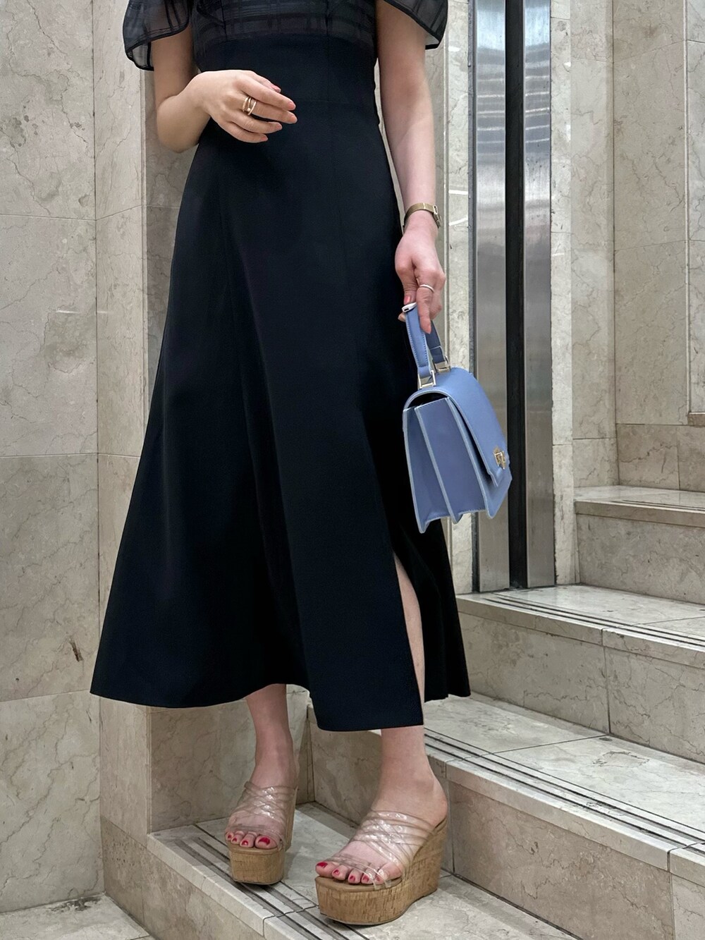 ブラック系のワンピース、ブルー系のハンドバッグ、その他のサンダルを着用したレディースの春コーディネートの9枚目の写真