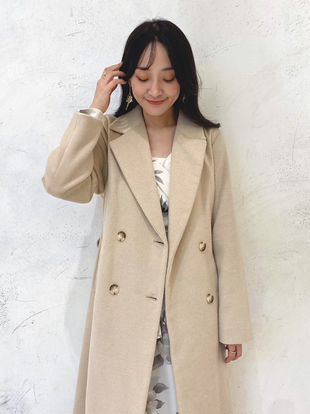ホワイト系のワンピース、ベージュ系のブーツ、ベージュ系のチェスターコートを着用したレディースの冬コーディネートの5枚目の写真