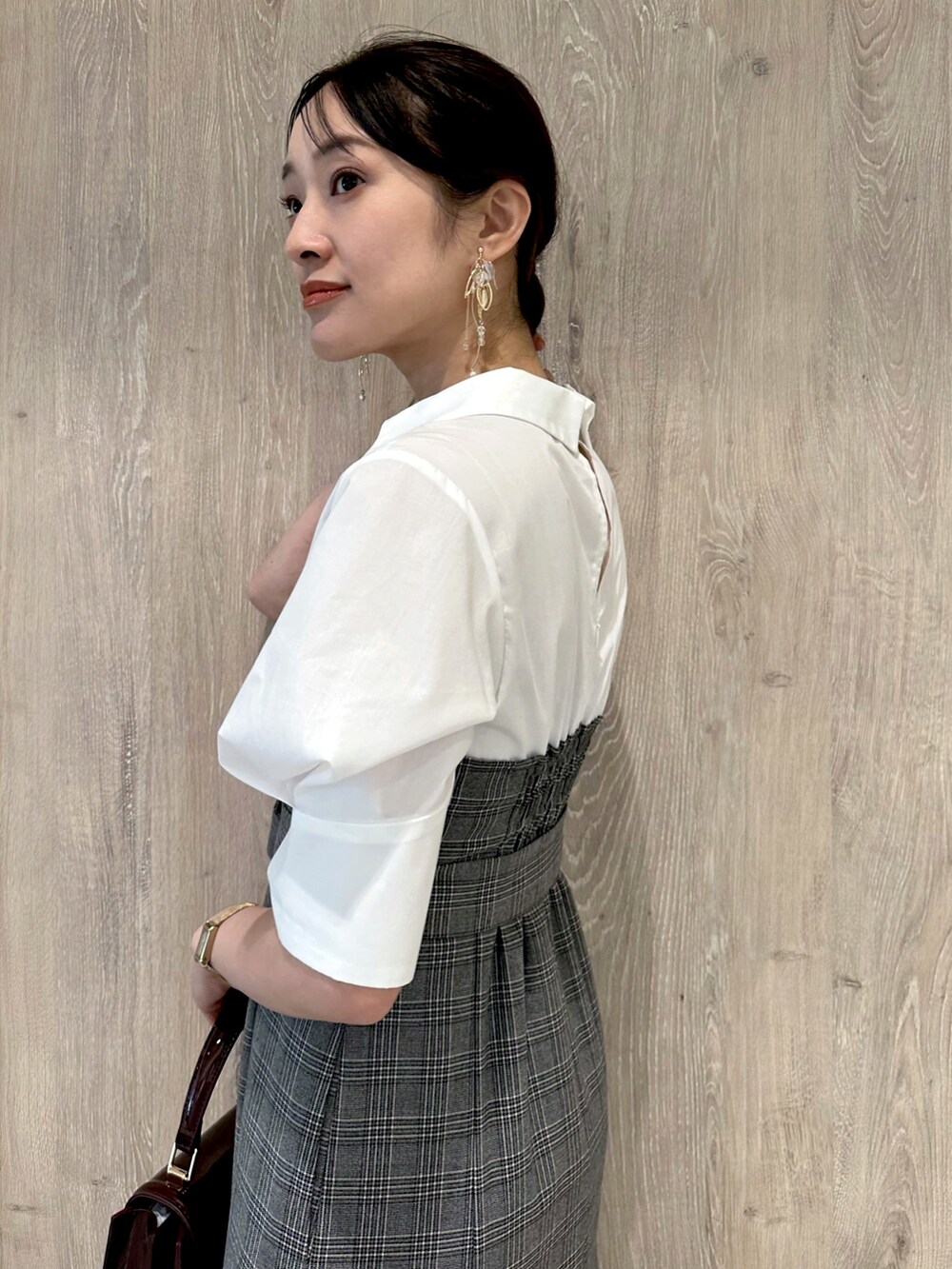 ブラウン系のパンプス、レッド系のハンドバッグ、その他のワンピースを着用したレディースの夏コーディネートの6枚目の写真