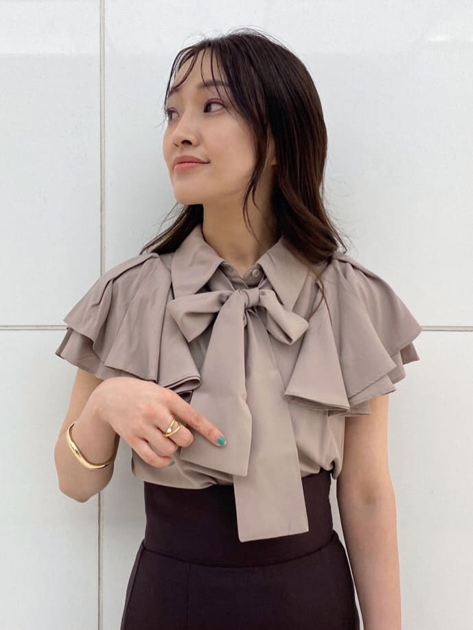 ピンク系のハンドバッグ、ブラウン系のサンダル、ベージュ系のシャツ/ブラウスを着用したレディースの夏コーディネートの5枚目の写真