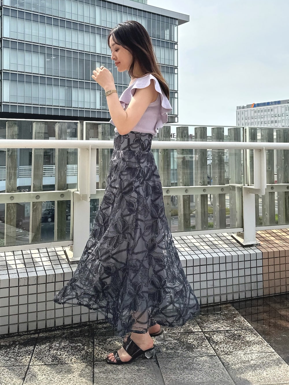 ブラウン系のサンダル、ブラック系のチューブトップ、グレー系のスカートを着用したレディースの夏コーディネートの3枚目の写真