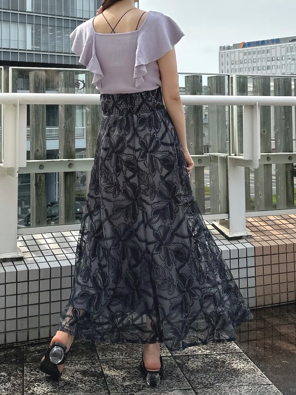 ブラウン系のサンダル、ブラック系のチューブトップ、グレー系のスカートを着用したレディースの夏コーディネートの4枚目の写真