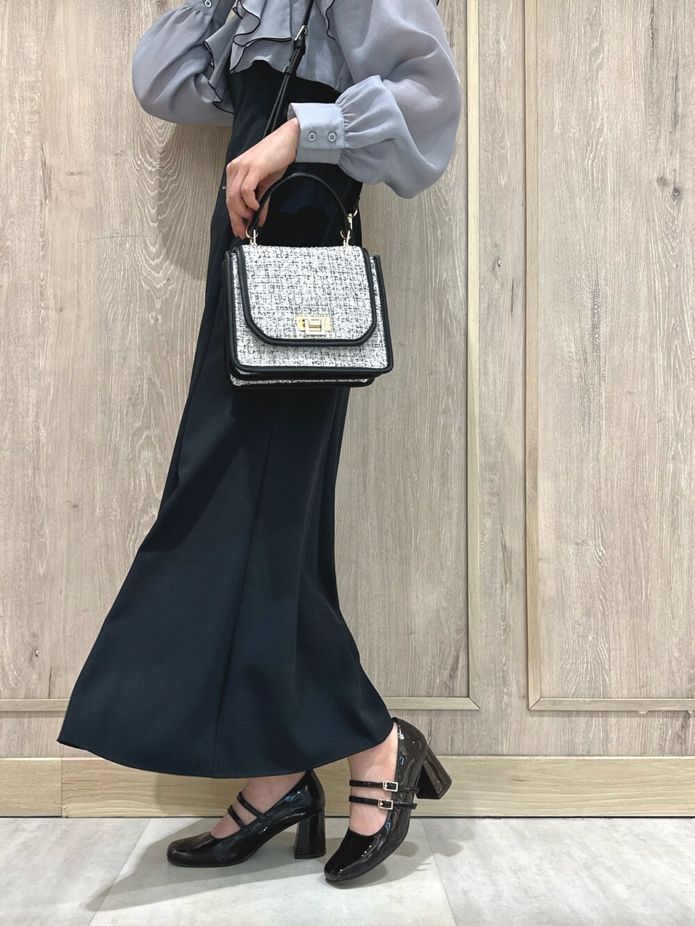 ブラック系のショルダーバッグ、グレー系のワンピース、ブラウン系のパンプスを着用したレディースの冬コーディネートの9枚目の写真