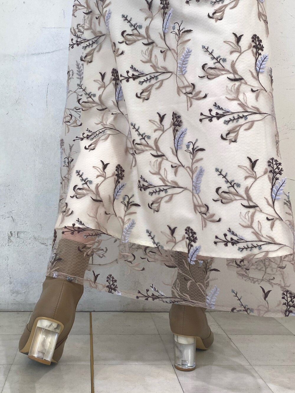 ブラウン系のニット/セーター、ピンク系のスカート、ベージュ系のブーツを着用したレディースの秋コーディネートの9枚目の写真