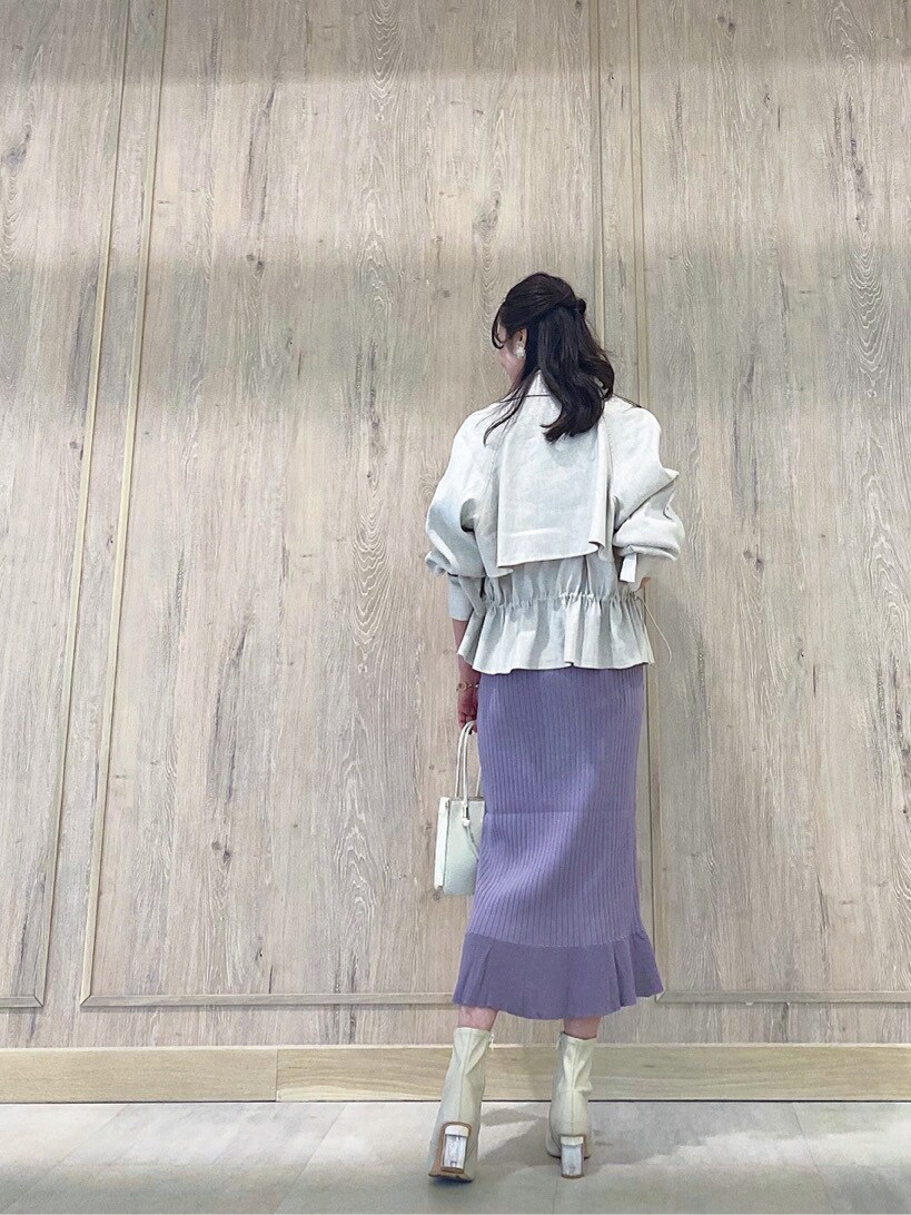 パープル系のワンピース、ホワイト系のブーツ、ホワイト系のハンドバッグを着用したレディースの冬コーディネートの3枚目の写真