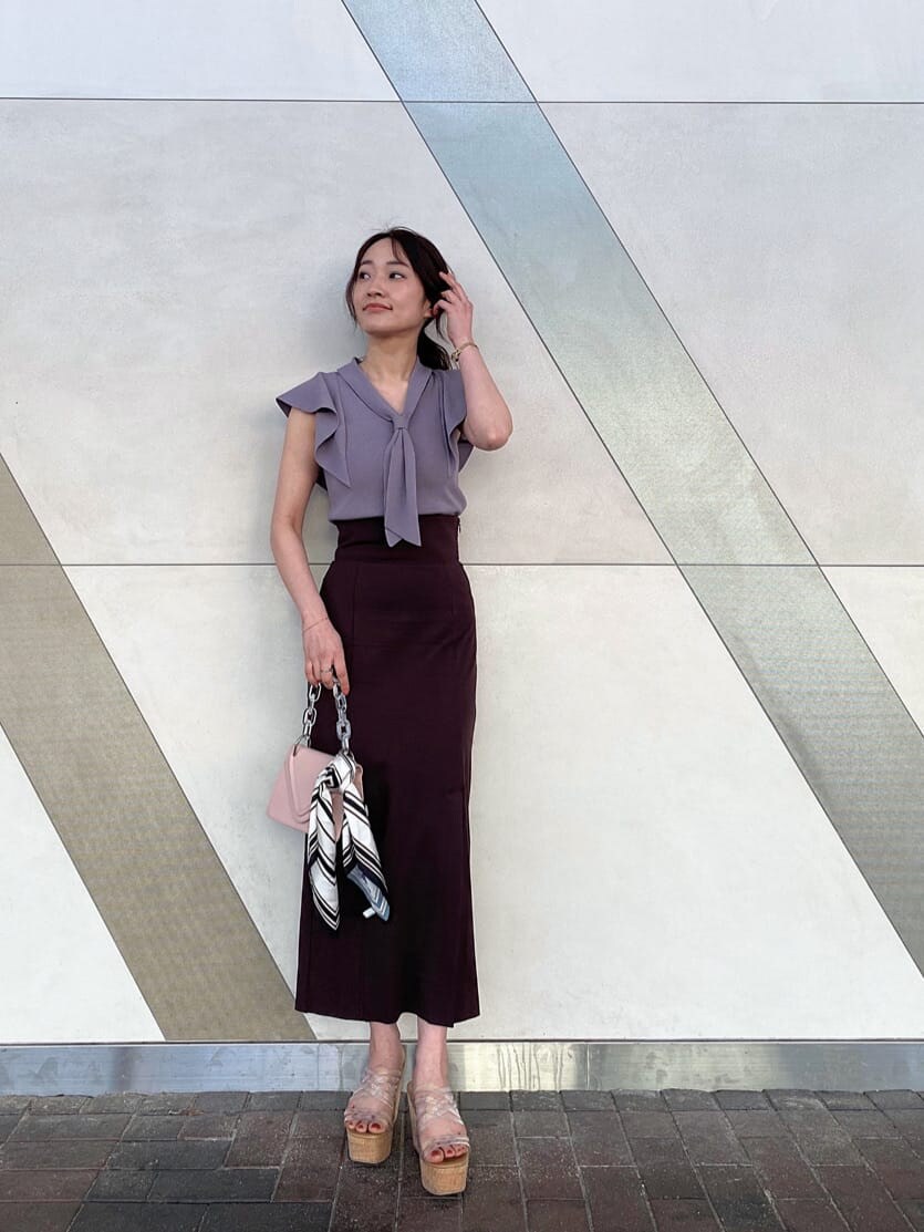 ピンク系のショルダーバッグ、グレー系のニット/セーター、ブラウン系のスカートを着用したレディースの春コーディネートの2枚目の写真