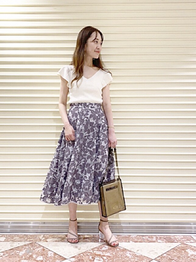 ブラウン系のサンダル、ブラック系のハンドバッグを着用したレディースの夏コーディネートの3枚目の写真