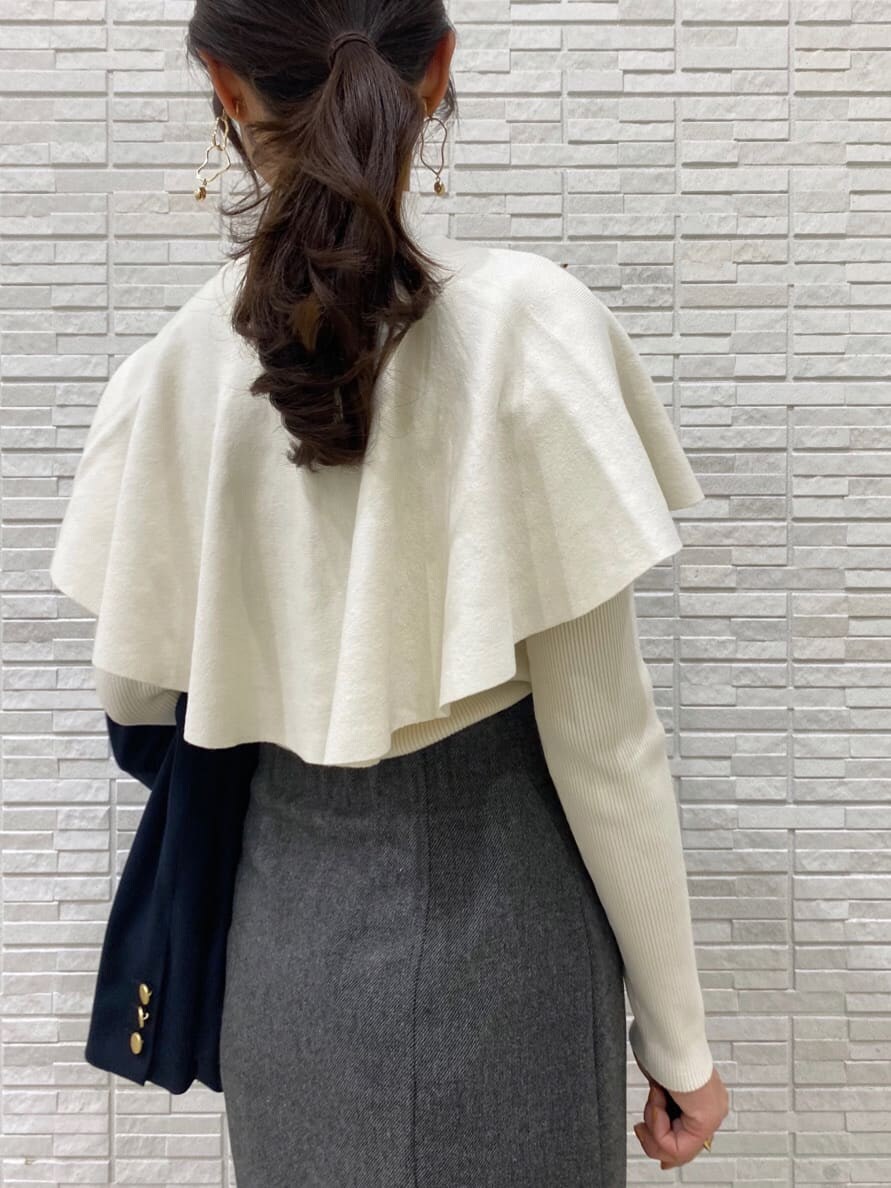 ブラック系のブーツ、ブルー系のテーラードジャケット、グレー系のスカートを着用したレディースの秋コーディネートの10枚目の写真