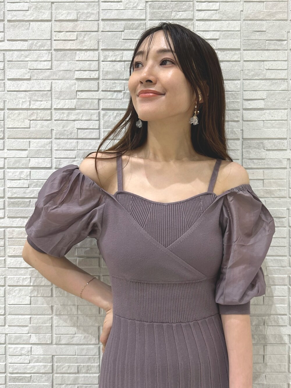 ブラウン系のパンプス、ブラック系のハンドバッグ、パープル系のワンピースを着用したレディースの夏コーディネートの4枚目の写真