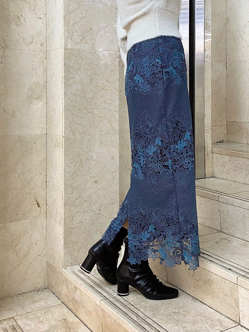 グリーン系のチェスターコート、ブルー系のスカート、ブラック系のその他シューズを着用したレディースの秋コーディネートの9枚目の写真