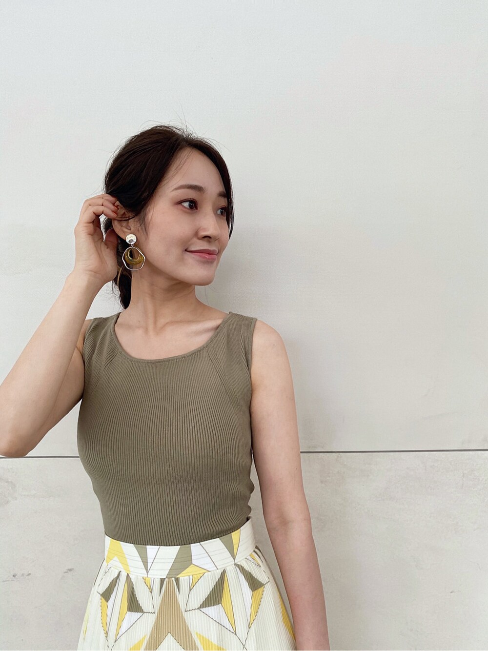 ブラウン系のトートバッグ、ベージュ系のサンダル、イエロー系のスカートを着用したレディースの夏コーディネートの4枚目の写真