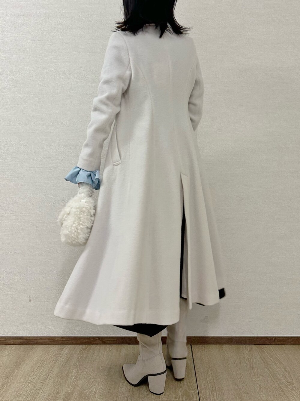 グレー系のブーツ、グレー系のニット/セーター、ブラック系のスカートを着用したレディースの冬コーディネートの4枚目の写真