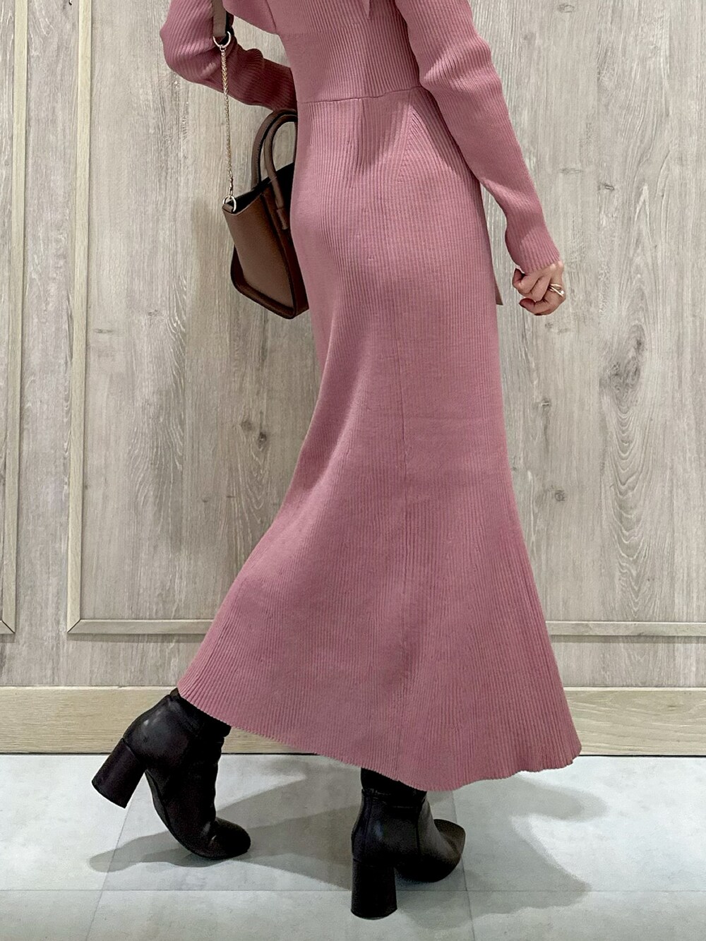 ピンク系のワンピース、ブラウン系のハンドバッグ、ブラウン系のブーツを着用したレディースの冬コーディネートの9枚目の写真