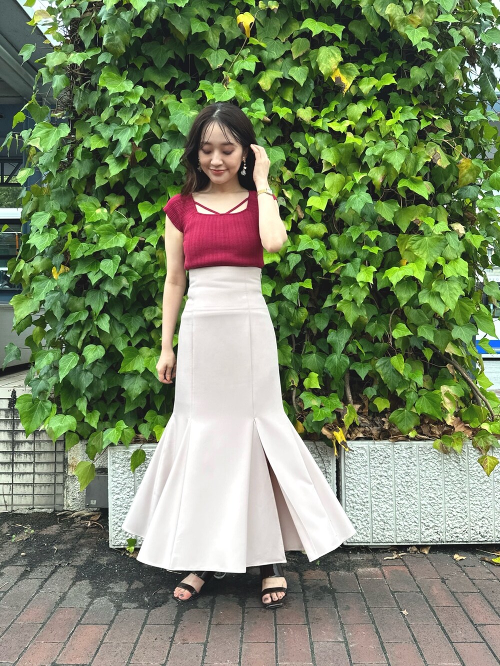 ブラウン系のサンダル、レッド系のニット/セーター、ピンク系のスカートを着用したレディースの夏コーディネートの2枚目の写真