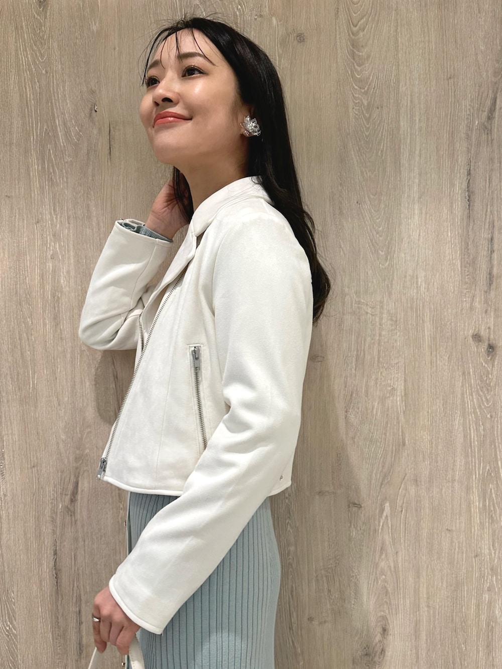 ホワイト系のハンドバッグ、ホワイト系のブーツ、ブルー系のワンピースを着用したレディースの冬コーディネートの6枚目の写真