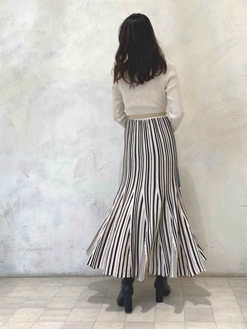 ブルー系のハンドバッグ、ブラック系のライダースジャケット、ホワイト系のワンピースを着用したレディースの冬コーディネートの10枚目の写真