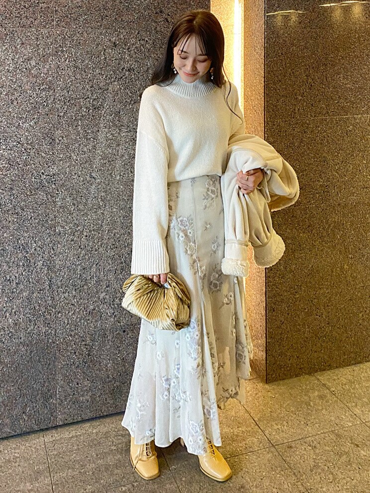 ベージュ系のクラッチバッグ、ホワイト系のムートンコート、ホワイト系のニット/セーターを着用したレディースの秋コーディネートの6枚目の写真