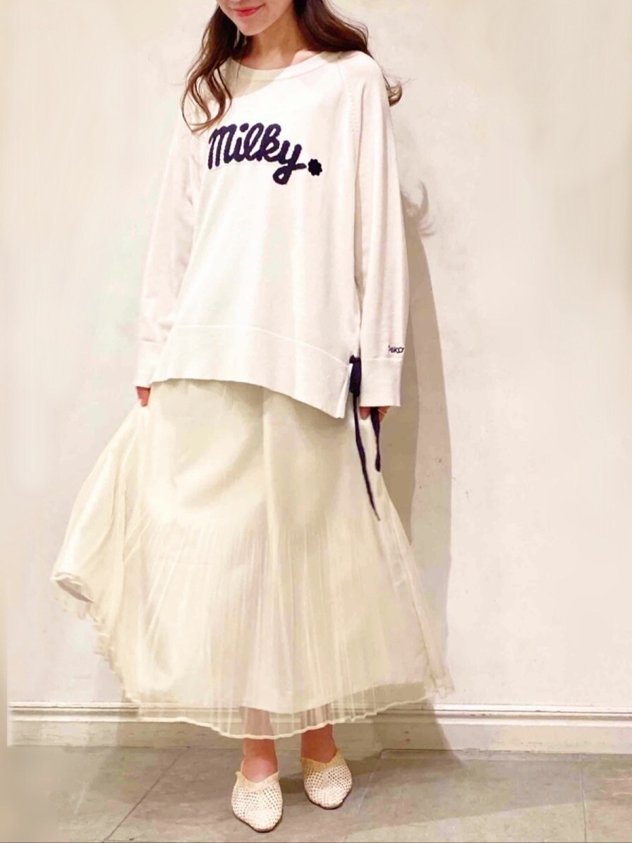 イエロー系のスカート、ベージュ系のパンプス、ホワイト系のニット/セーターを着用したレディースの冬コーディネートの4枚目の写真