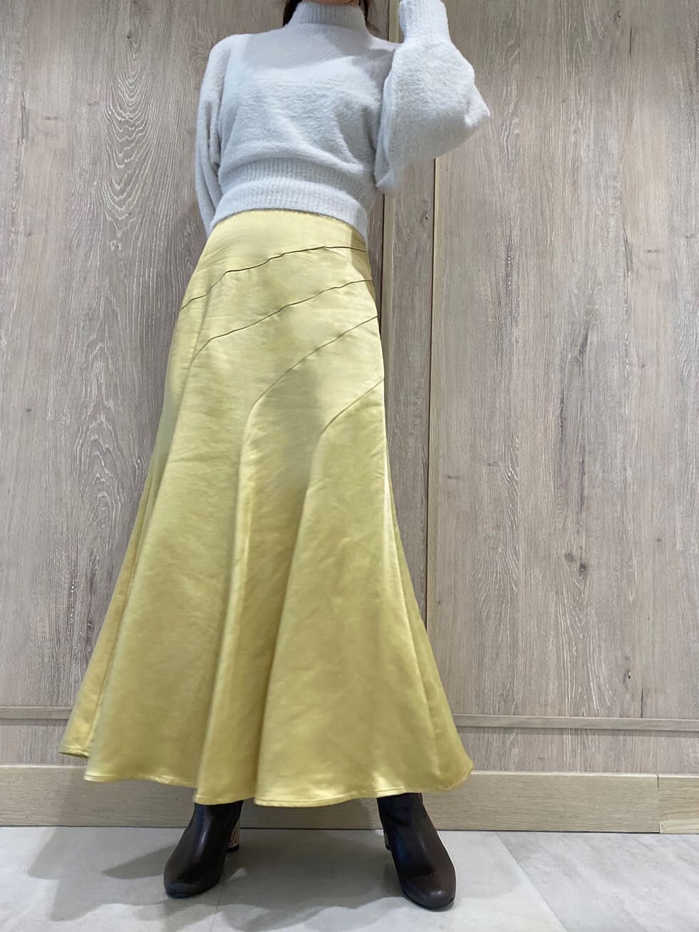 ブラウン系のハンドバッグ、ブラウン系のその他シューズ、イエロー系のスカートを着用したレディースの秋コーディネートの6枚目の写真