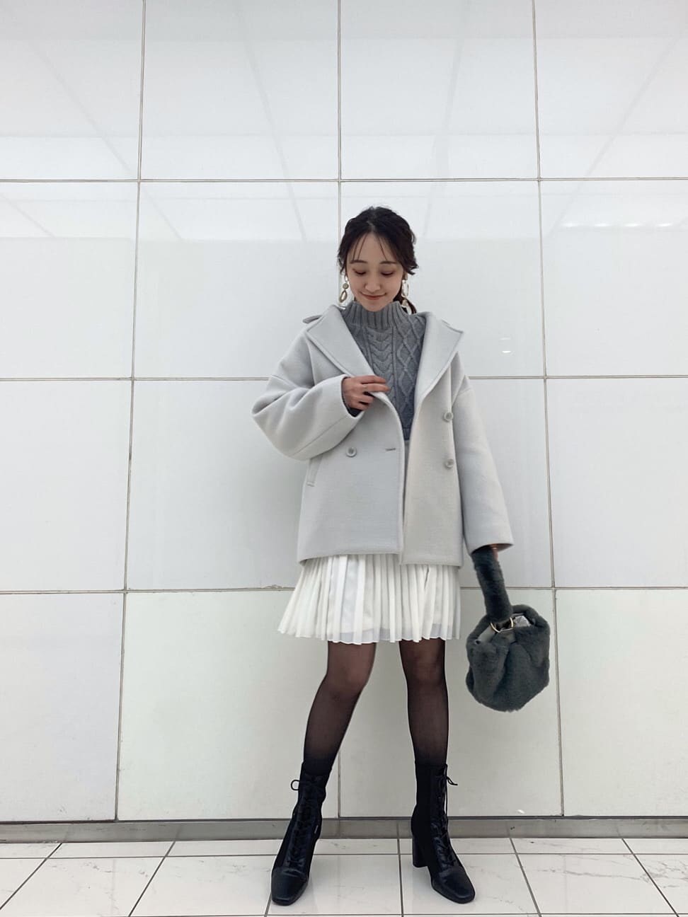 グリーン系のブルゾン、ブラック系のブーツ、グレー系のワンピースを着用したレディースの冬コーディネートの2枚目の写真