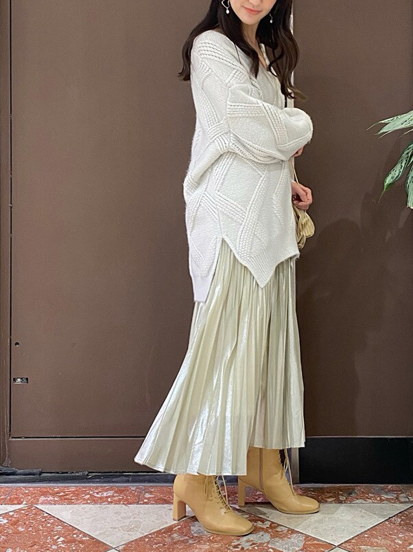 ベージュ系のクラッチバッグ、イエロー系のスカート、グレー系のニット/セーターを着用したレディースの秋コーディネートの3枚目の写真