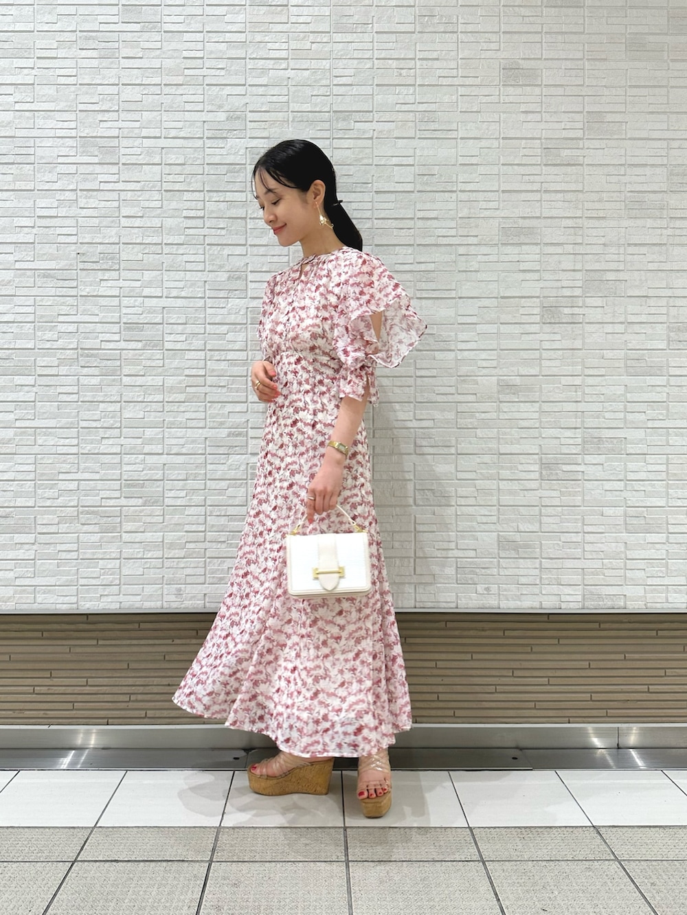 その他のサンダル、ピンク系のワンピース、ホワイト系のハンドバッグを着用したレディースの春コーディネートの3枚目の写真