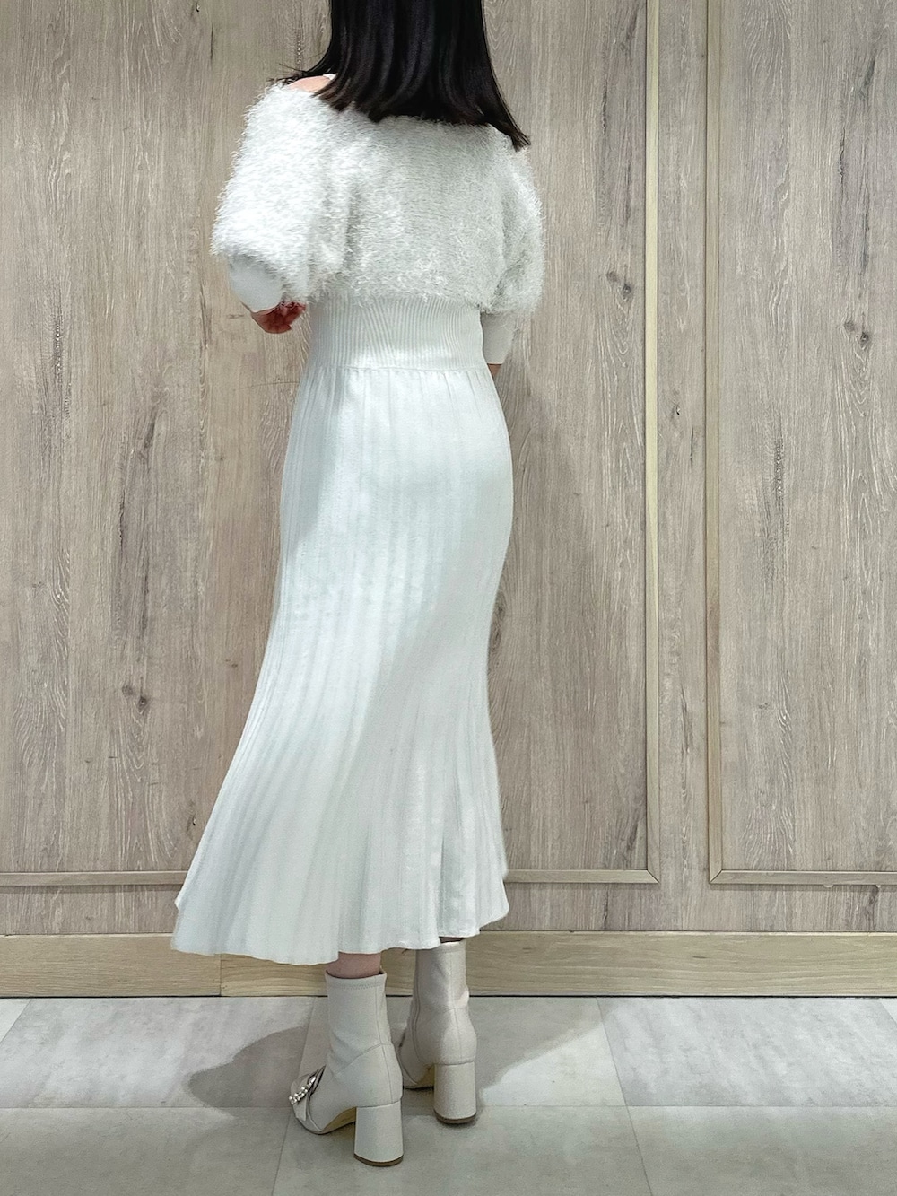 ホワイト系のブーツ、ホワイト系のワンピース、ゴールド系のイヤリングを着用したレディースの春コーディネートの4枚目の写真