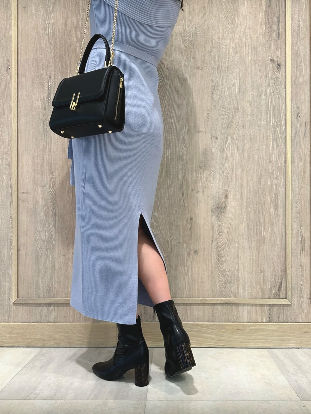 ブラック系のブーツ、ブルー系のワンピース、ブラック系のショルダーバッグを着用したレディースの冬コーディネートの8枚目の写真