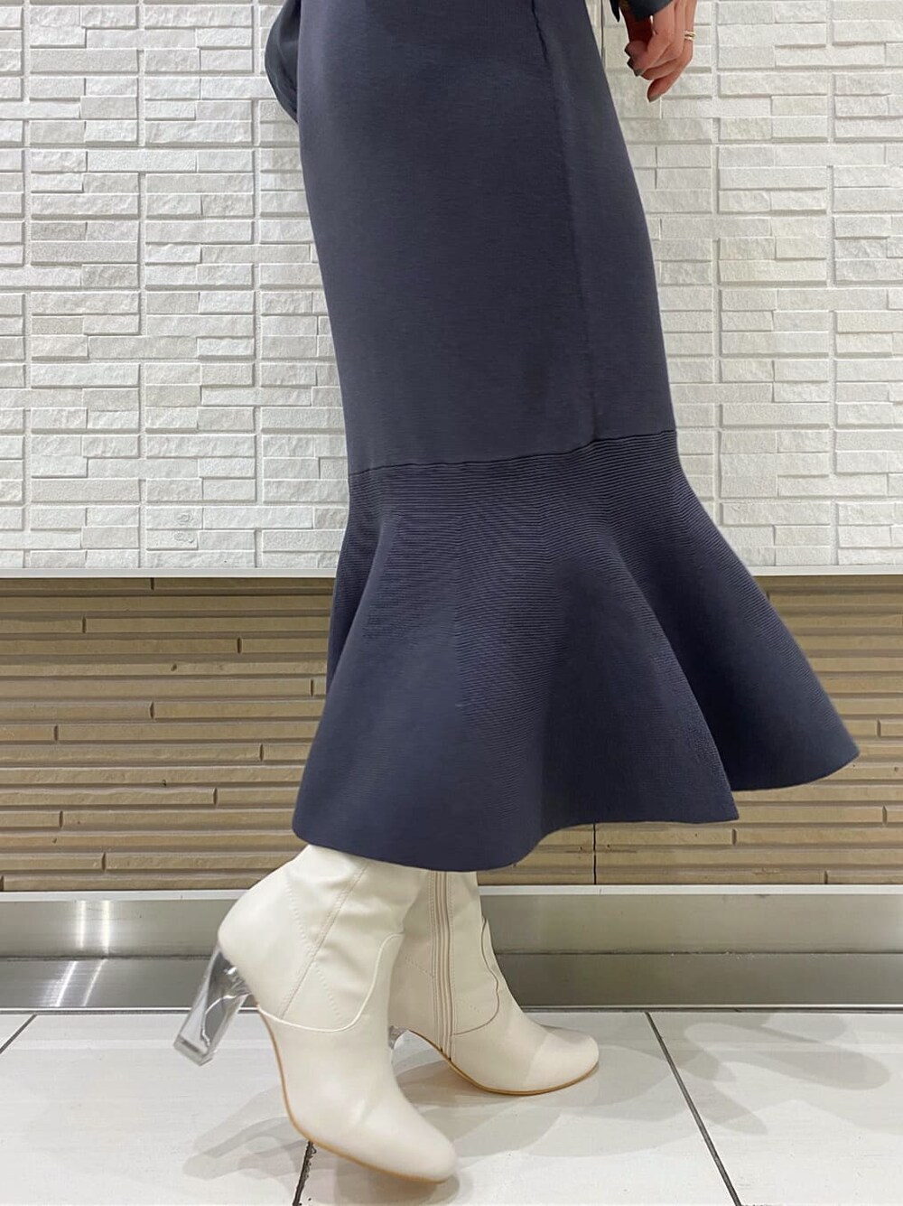 グレー系のテーラードジャケット、ブルー系のワンピース、ホワイト系のその他シューズを着用したレディースの冬コーディネートの10枚目の写真