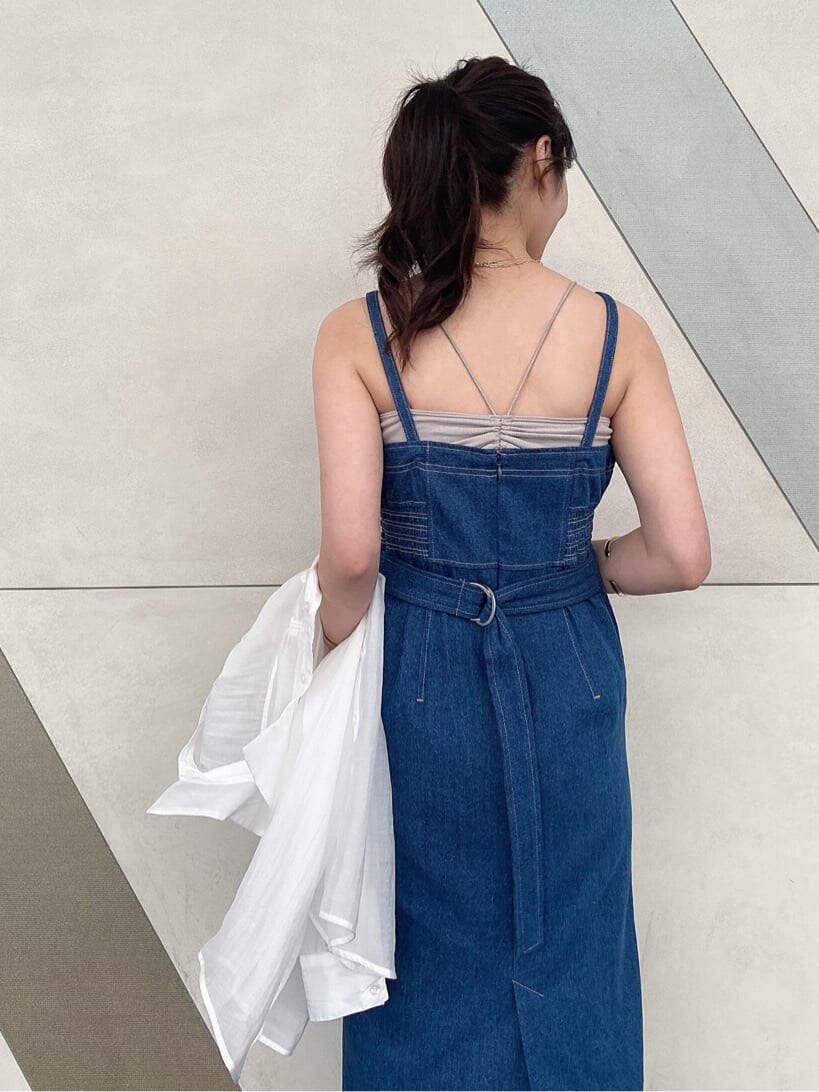 イエロー系のショルダーバッグ、ブルー系のジャンパースカート、ベージュ系のキャミソールを着用したレディースの春コーディネートの7枚目の写真